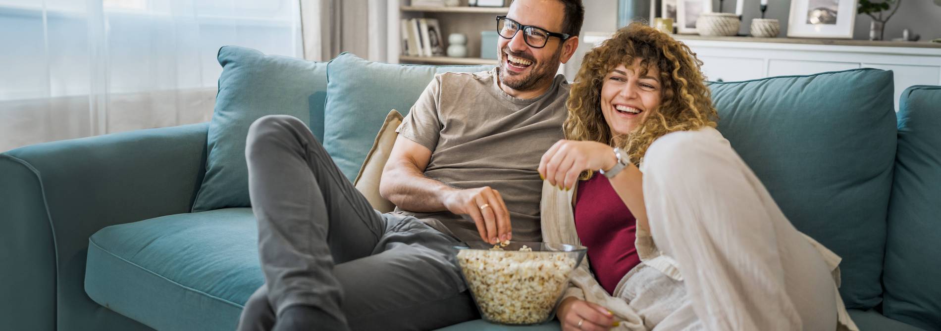 Couple on the sofa with popcorn watching TV