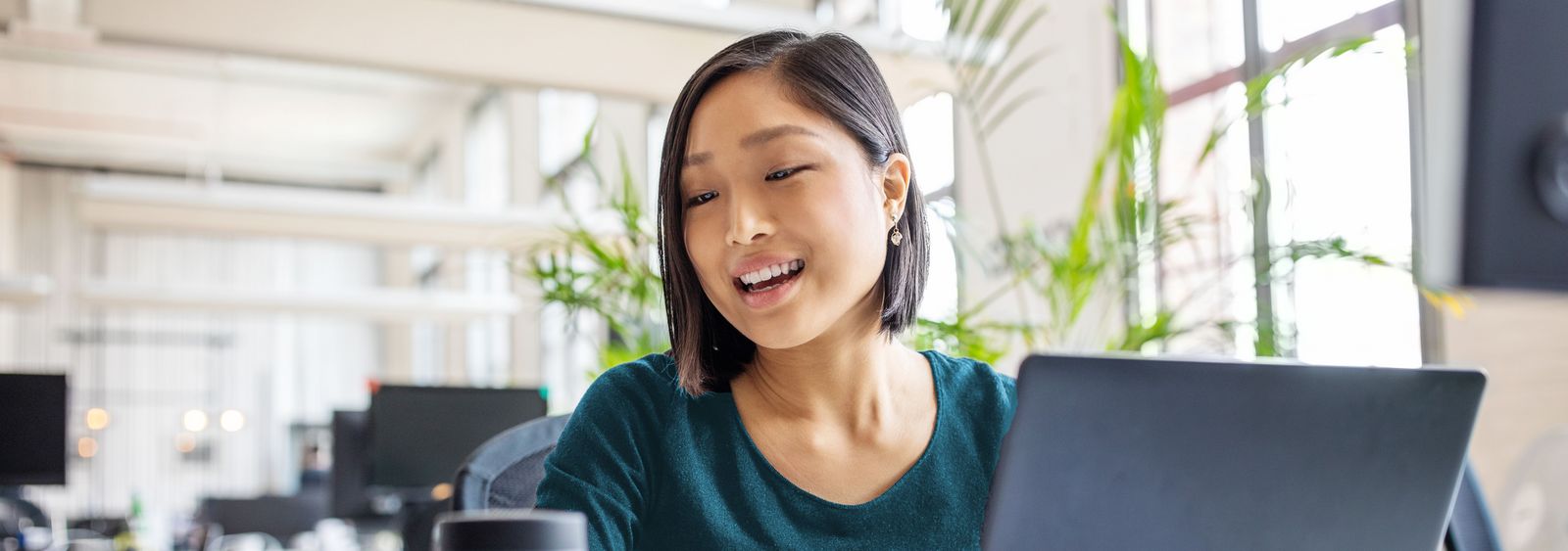 Woman on laptop talks to Alexa