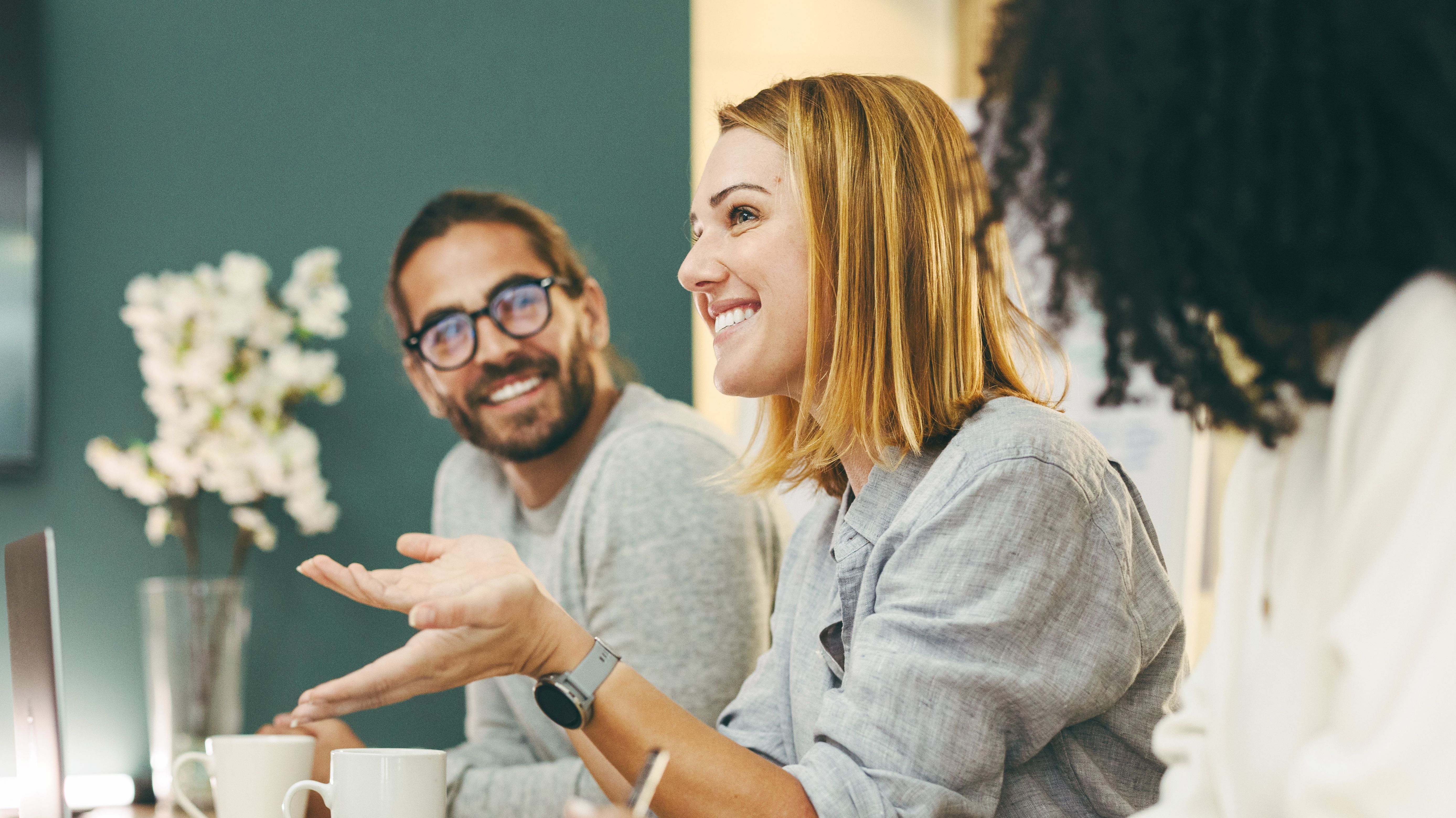 Four happy people around a desk during a conversation