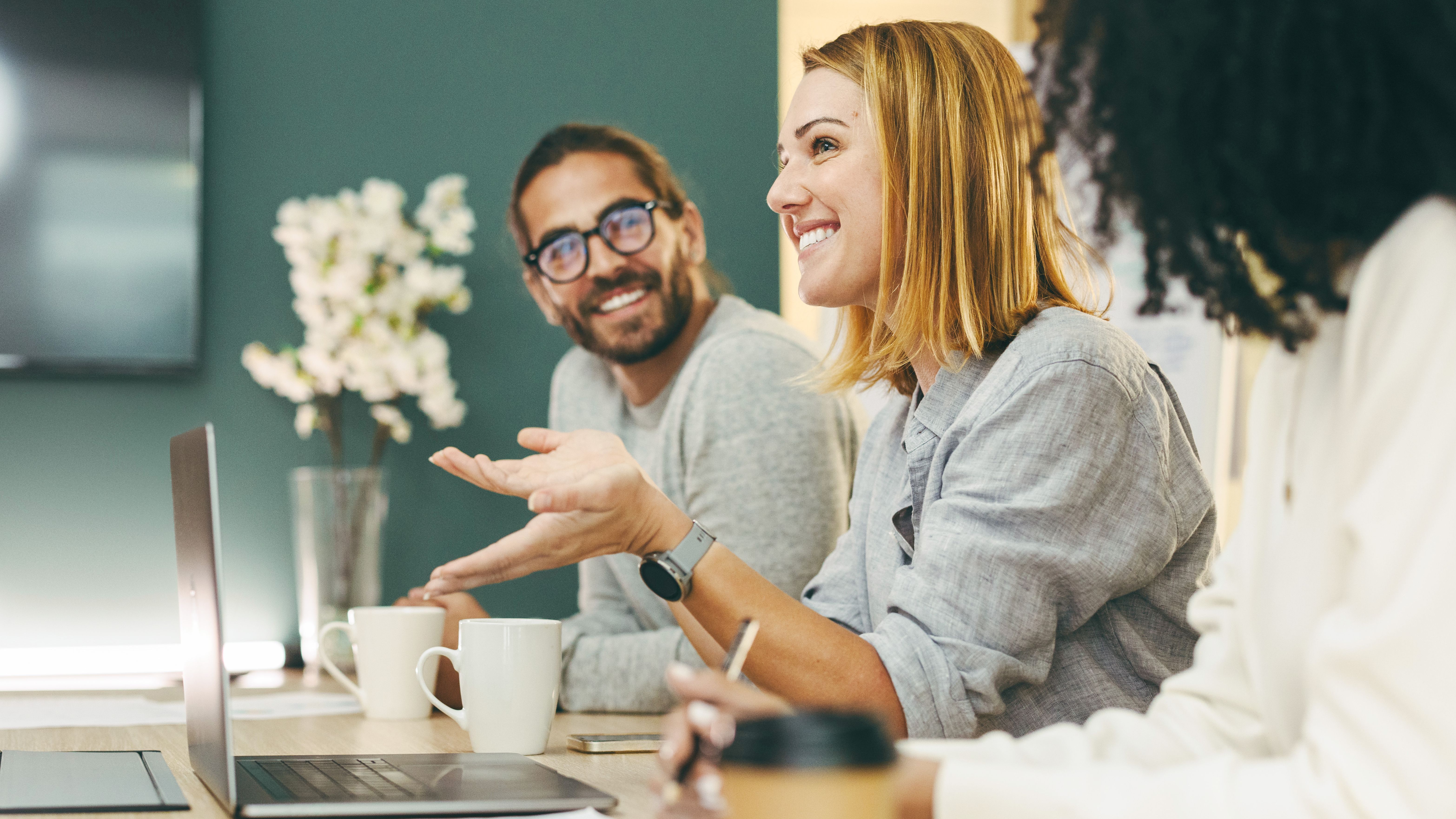 Four happy people around a desk during a conversation