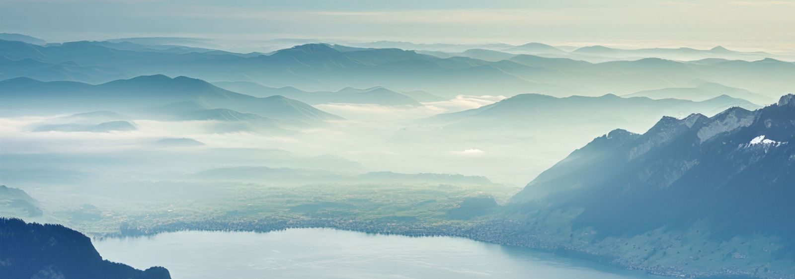 Far-reaching views over wooded hills with light wafts of mist