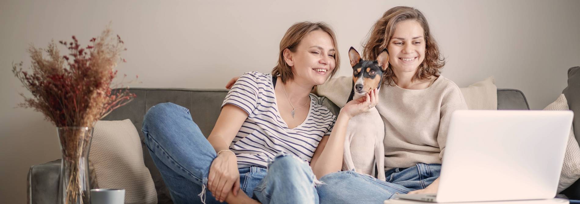 Zwei Girls mit Hund auf dem Sofa