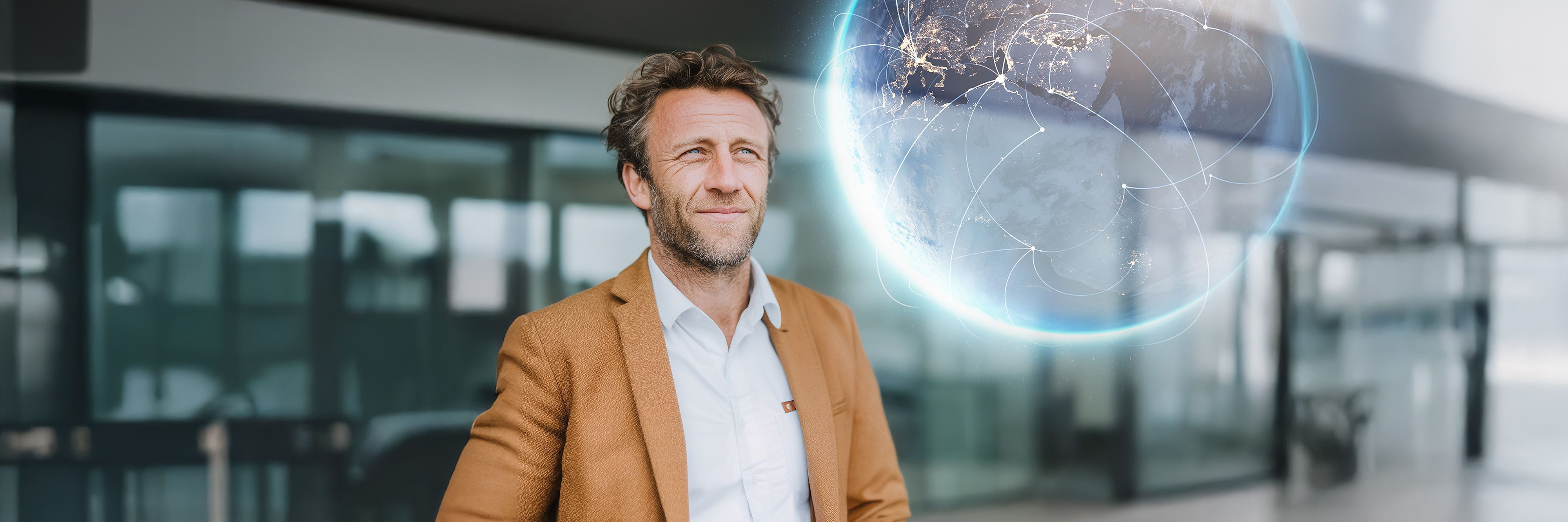 A man in a light brown suit looks thoughtfully into the distance. Next to him floats a digitally rendered globe with glowing network lines symbolizing global connections.